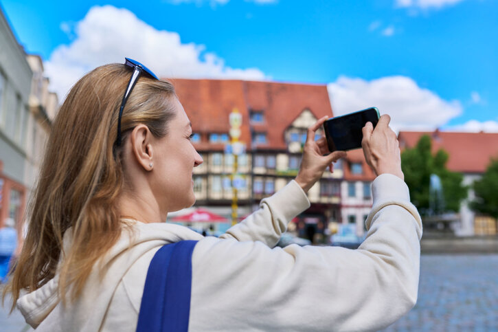 Touristin fotografiert Altstadt mit dem Smartphone